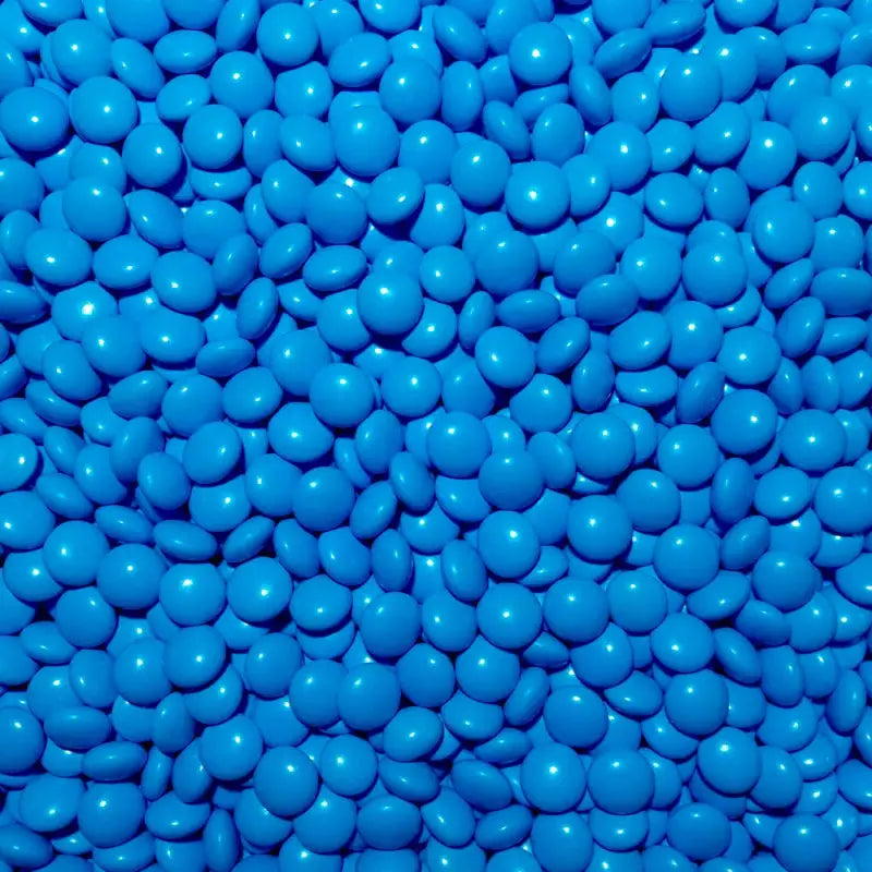 A close-up image of blue colored chocolate pebbles filling the entire frame.