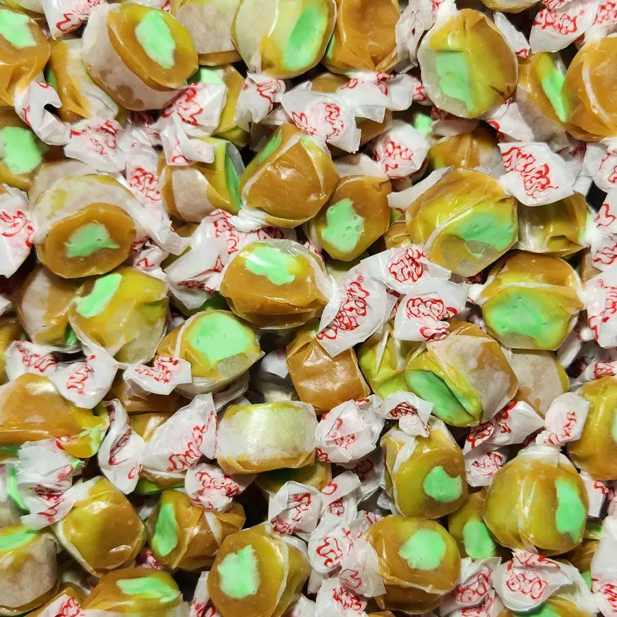 Assorted taffy candies with green and brown accents in clear wrappers. Caramel Apple Flavour