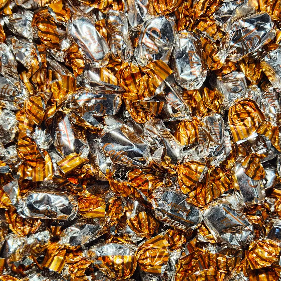 Close-up of gold and silver foil-wrapped candies with "coffee" flavour
