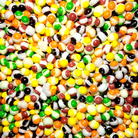 An assortment of freeze dried skittles in a pile together in vibrant colours