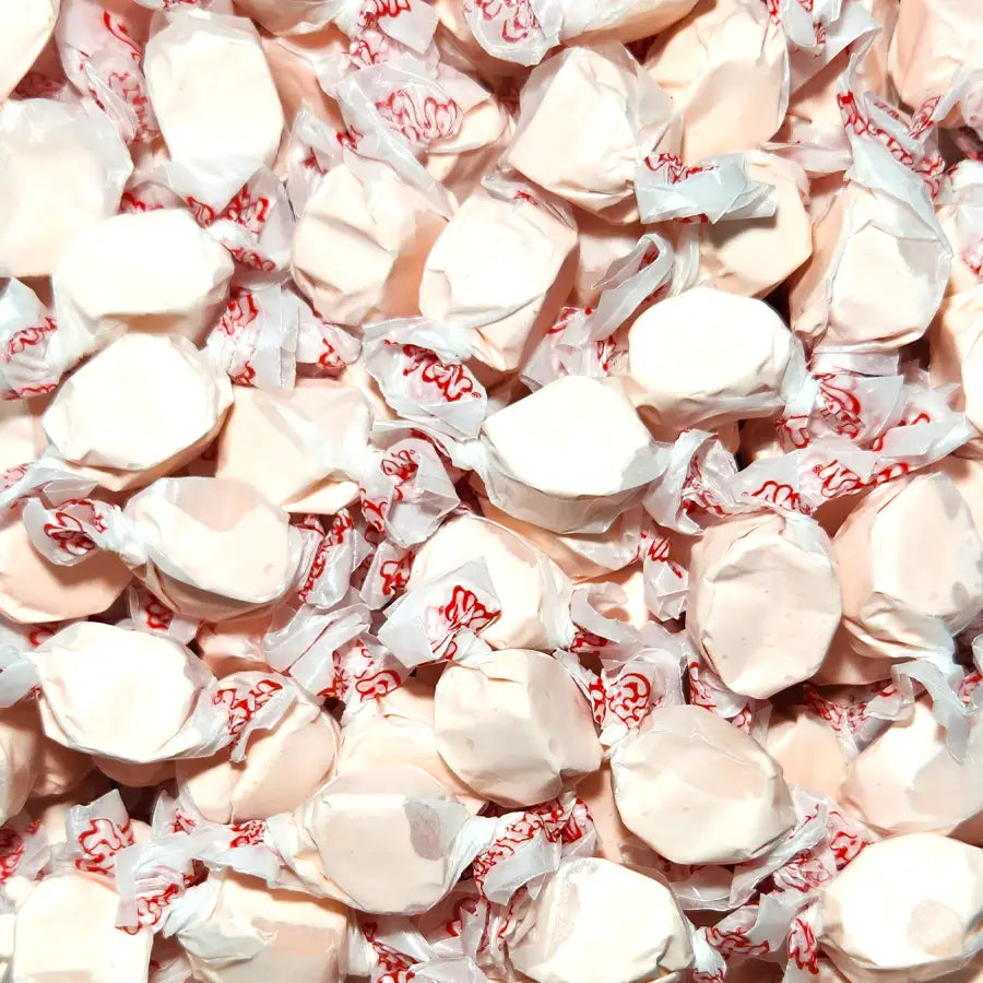 Close-up of white taffy candies in red and white wrappers. Bubblegum Flavour