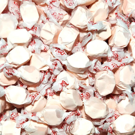 Close-up of white taffy candies in red and white wrappers. Bubblegum Flavour
