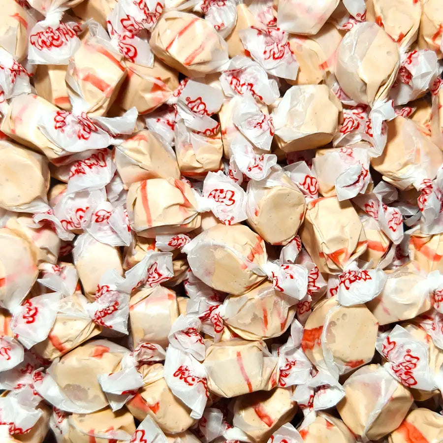 Close-up of wrapped taffy candies with visible brand name. Cherry Cola Flavour