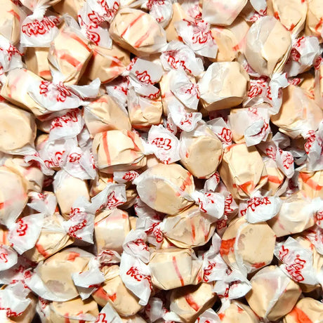 Close-up of wrapped taffy candies with visible brand name. Cherry Cola Flavour