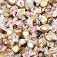 Assorted caramel mocha taffy in clear wrappers with red text, close-up view