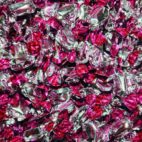 Close-up of pink and silver wrapped candies with "eclair" branding and hazelnut flavour