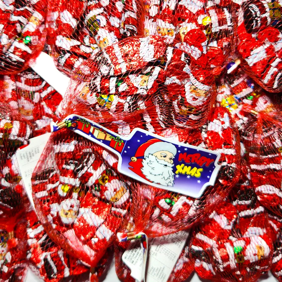 Red and white santa shaped foil wrapped chocolates in a red net bag