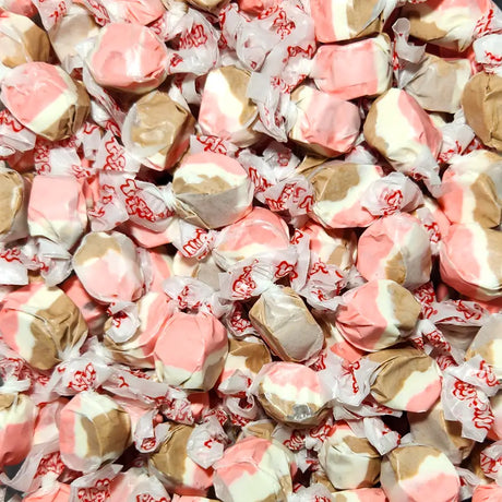 Assorted pink, white, and brown taffy candies in red and white wrappers. Neapolitan flavoured taffy