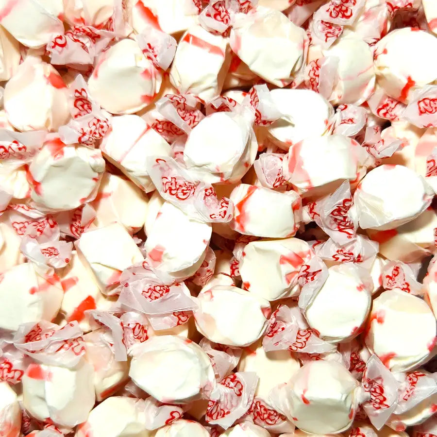 Close-up of white and red taffy pieces with visible text. Peppermint Flavour