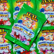 Multiple packages of TNT Super Sour sherbet filled candy with green packaging in 150 grams in sizing