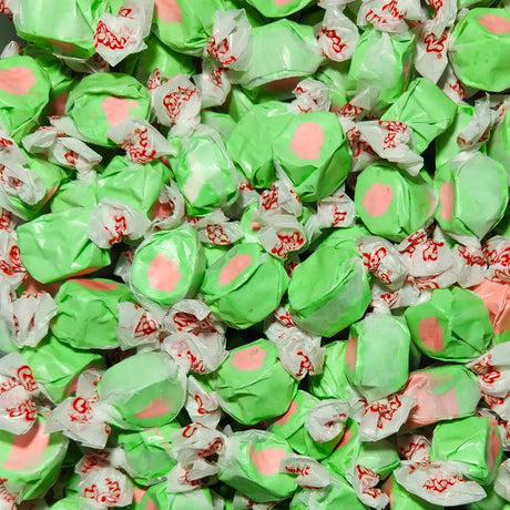 Close-up of green and pink candies with red text in clear wrappers. Watermelon Flavour